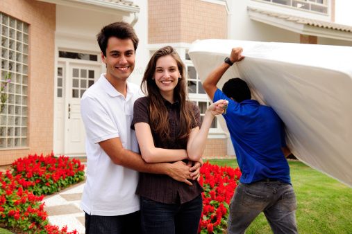 Pareja caminando hacia su casa nueva tras una mudanza